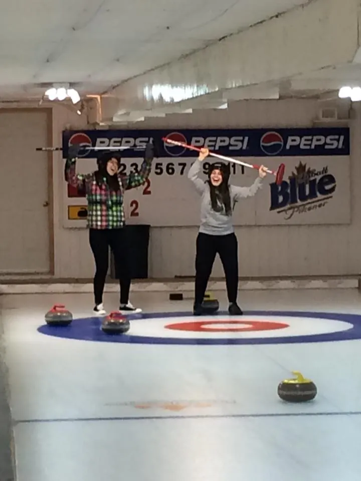 Students curling at an ice rink